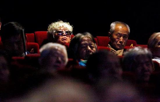 影院内，盲人听众在认真听电影。