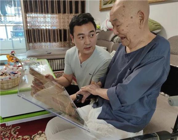 宋良友（右）在孙子宋辉的帮助下回想当年的战斗故事（9月11日摄）。 新华社记者 卢东方 摄