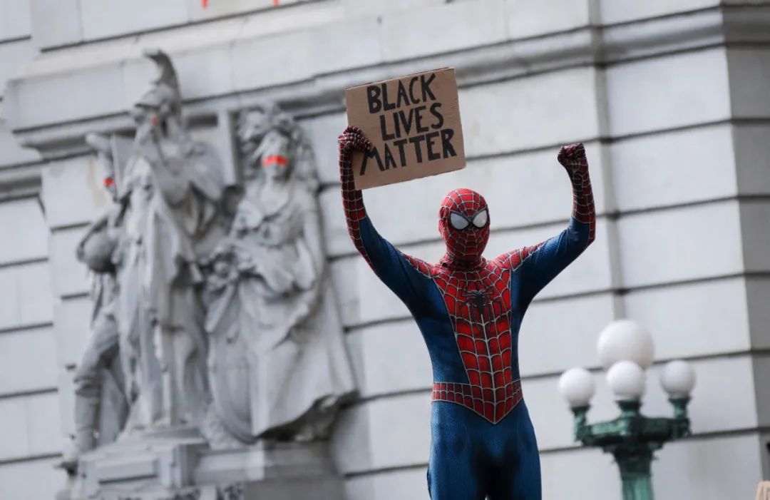 6月30日，一名打扮成“蜘蛛侠”的抗议者在美国纽约市政厅附近手举写有“黑人的命也是命”的标语。新华社记者王迎摄