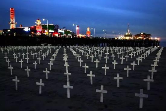 图为2007年11月25日,在美国加利福尼亚州圣莫尼卡海滨,人们在沙滩上竖起十字架,纪念在伊拉克战争中死亡的美军士兵。图源:新华网