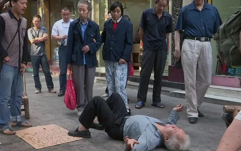 在一次被城管要求搬离后,王天成躺在地上向围观群众诉苦。受访者供图