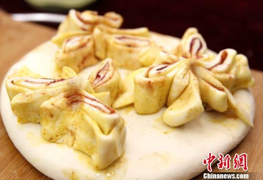 资料图:图为用上过各色“色素”的面皮制成的花朵,用以装饰月饼。 张海雯 摄