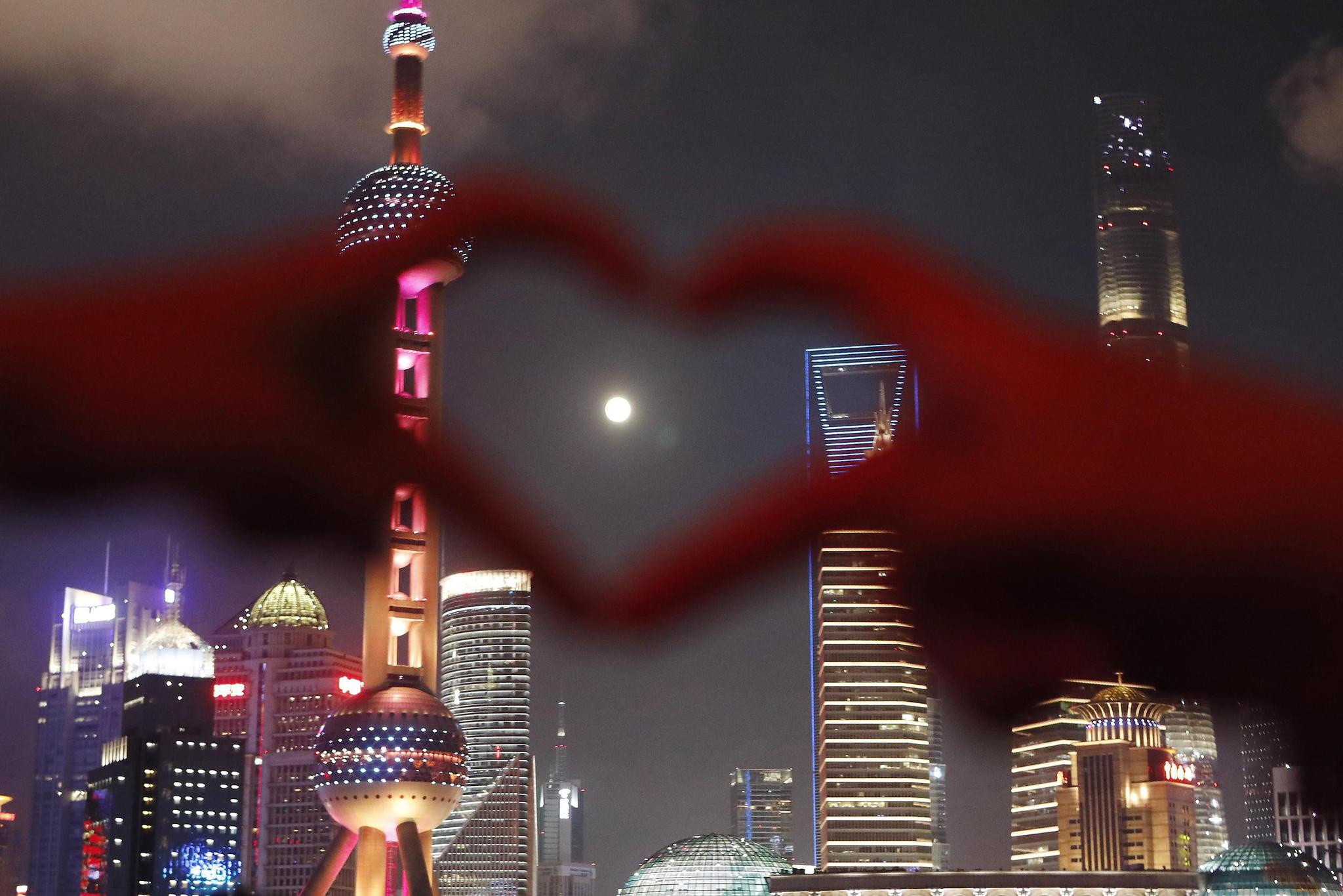 市民和游客在上海外滩滨江步道上拍照、赏月。视觉中国 图