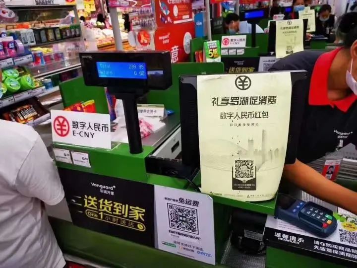 图为在深圳华润万家罗湖区春风店,人工收银台有标识提示顾客可使用数字人民币。
