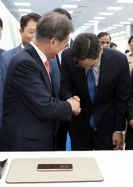 资料图:文在寅与李在镕握手(韩联社)