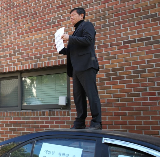 有男子在李明博住宅外示威,要求李明博谢罪(韩联社)