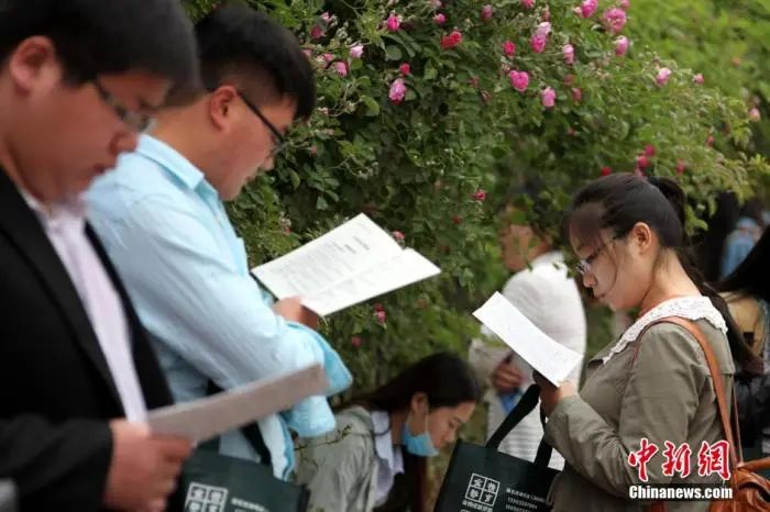 资料图:考生在公务员考试考场外复习。中新社发 吉 喆 摄 图片来源:cnsphoto