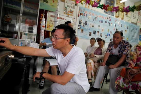 王伟力细心地为听众调音响设备,他们对声音质量要求很高。