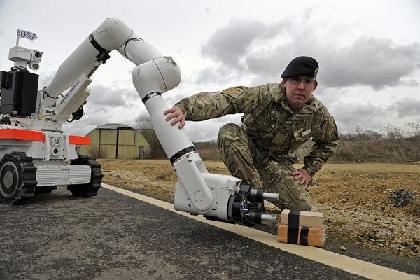 资料图片：英陆军士兵与排爆机器人合影。（英国防部官网）
