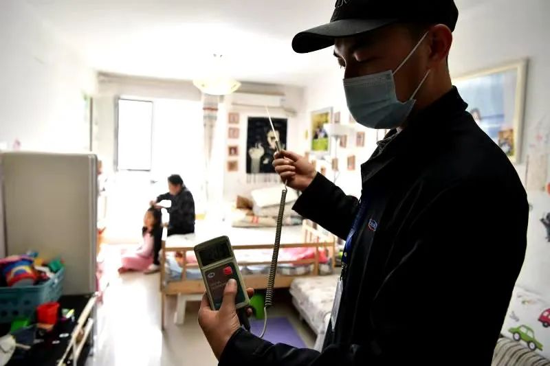 测温员在居民家中测温,仪器显示室温20.9℃。摄影吴江