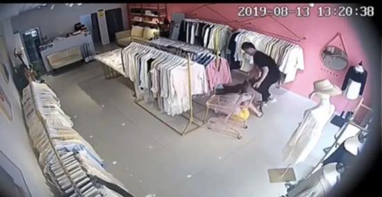 ▲杨宁试图拉开店门逃走,被丈夫拉回摔在地上。视频截图