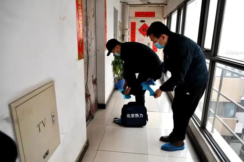 测温员带上鞋套,准备进入居民家中测量室温。摄影吴江